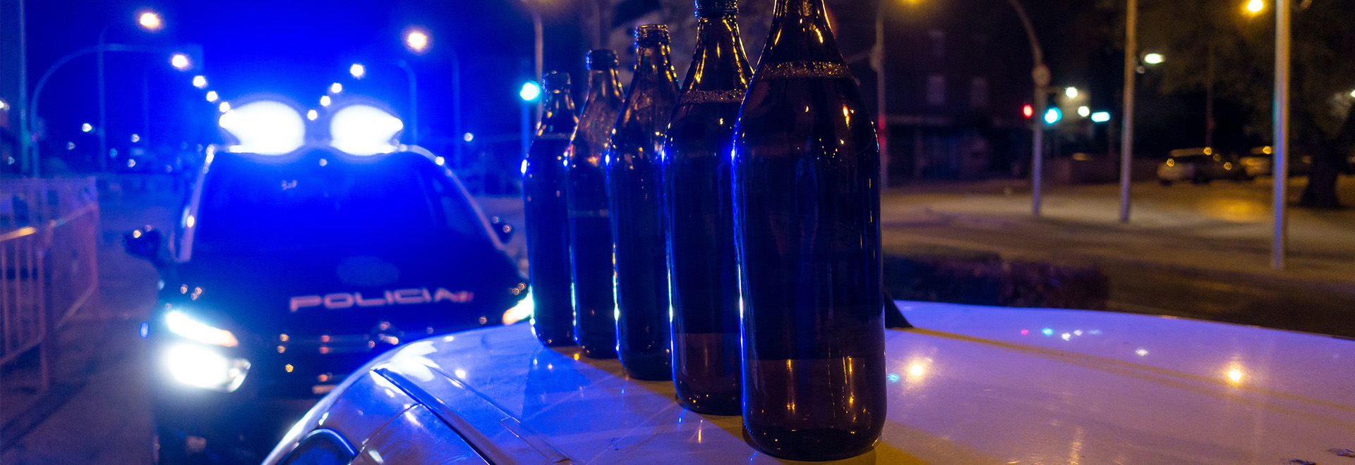Several liter sof beer on top of a car that is under police control