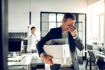 man getting fired carrying box of stuff