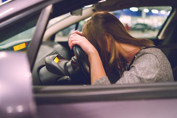 woman with head on steering wheel